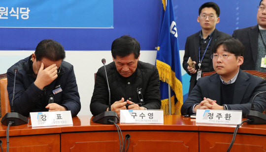 22일 오전 국회 더불어민주당 원내대표실에서 열린 택시와 플랫폼의 상생발전을 위한 사회적 대타협기구 출범식에 참석한 구수영 전국민주택시노동조합연맹 위원장(왼쪽), 정주환 카카오모빌리티 대표가 홍영표 원내대표의 발언을 경청하고 있다. . 연합뉴스
